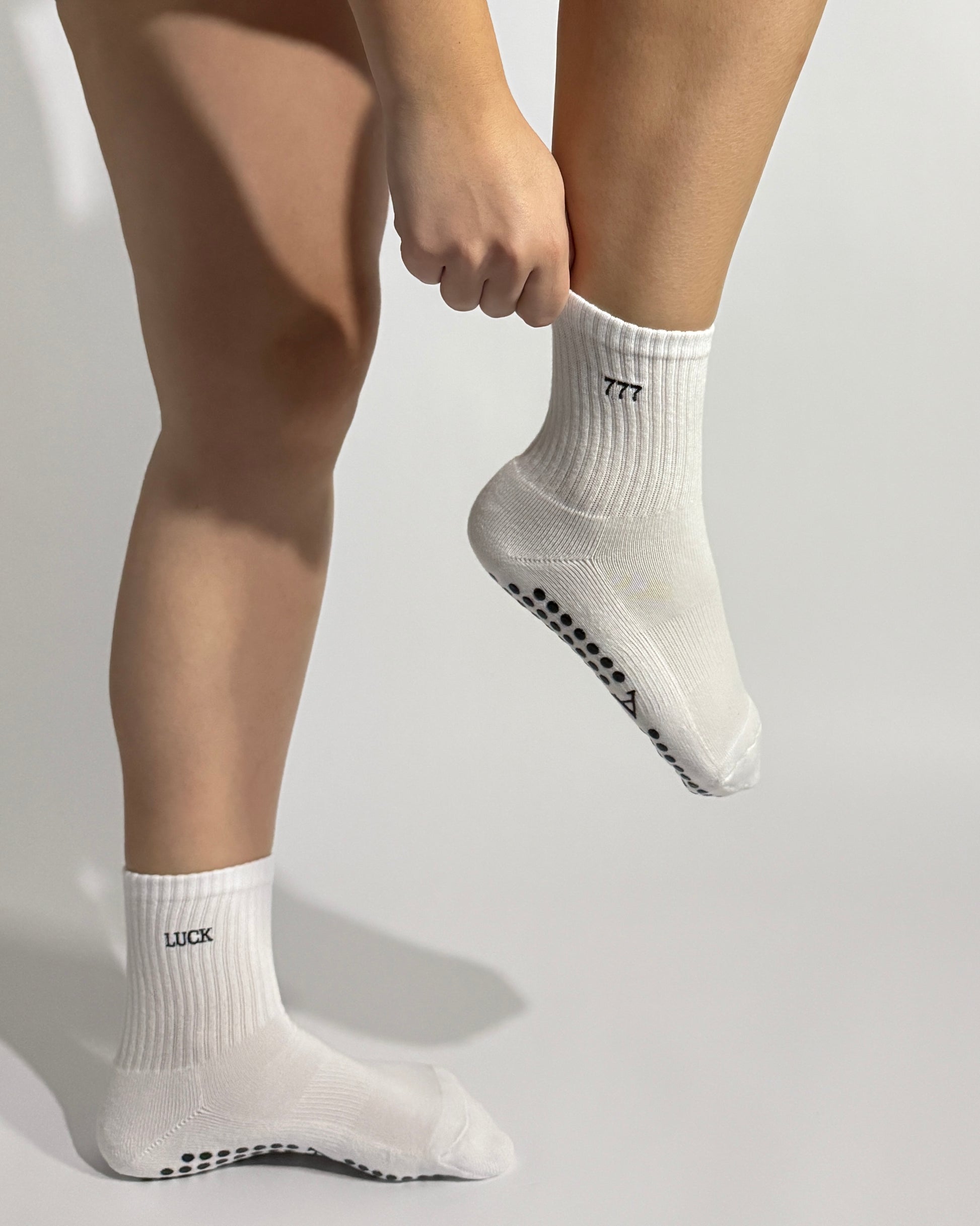 White Pilates grip socks worn by a Pilates teacher