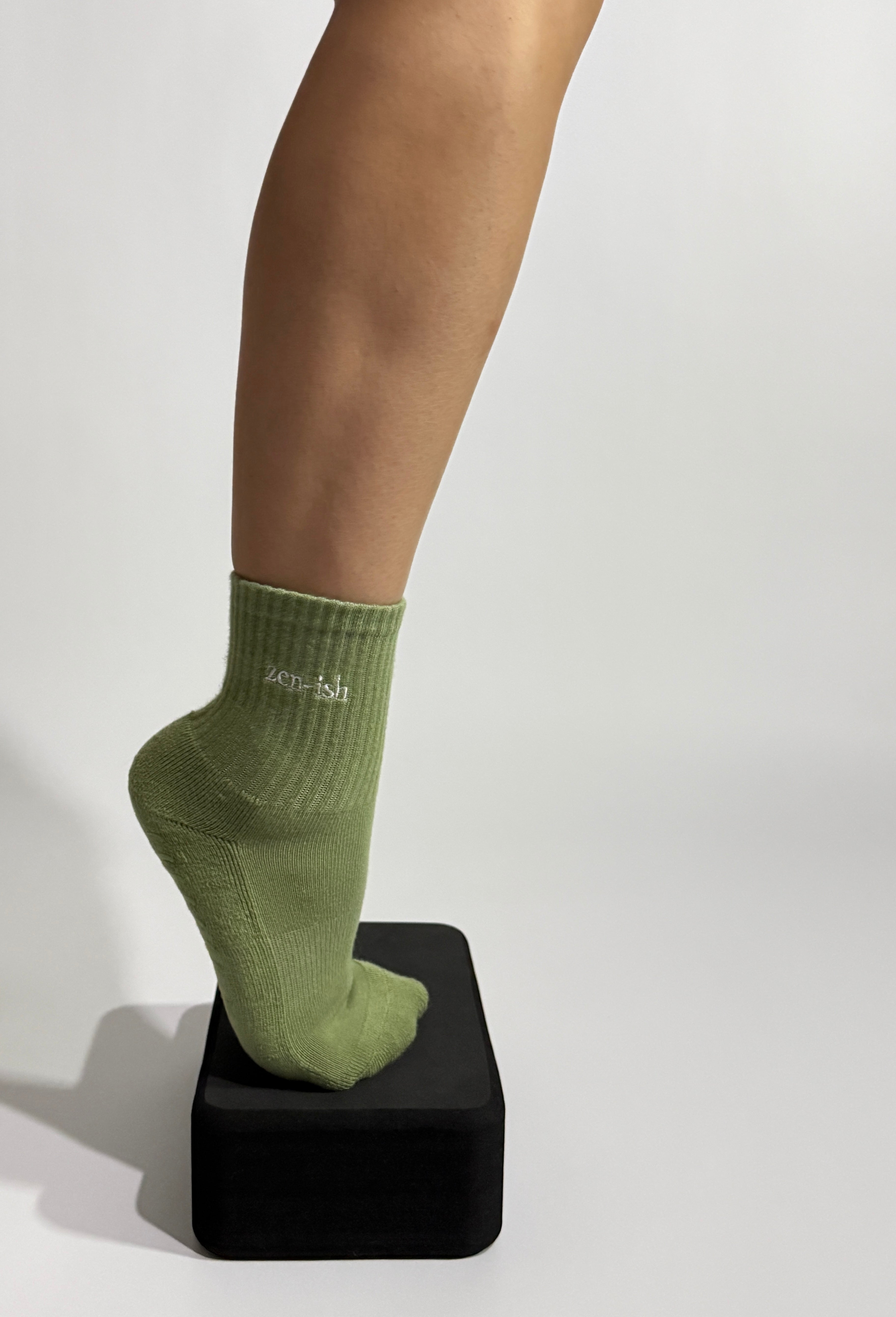 Zen-ish Pilates grip socks worn during Pilates exercise on back box
