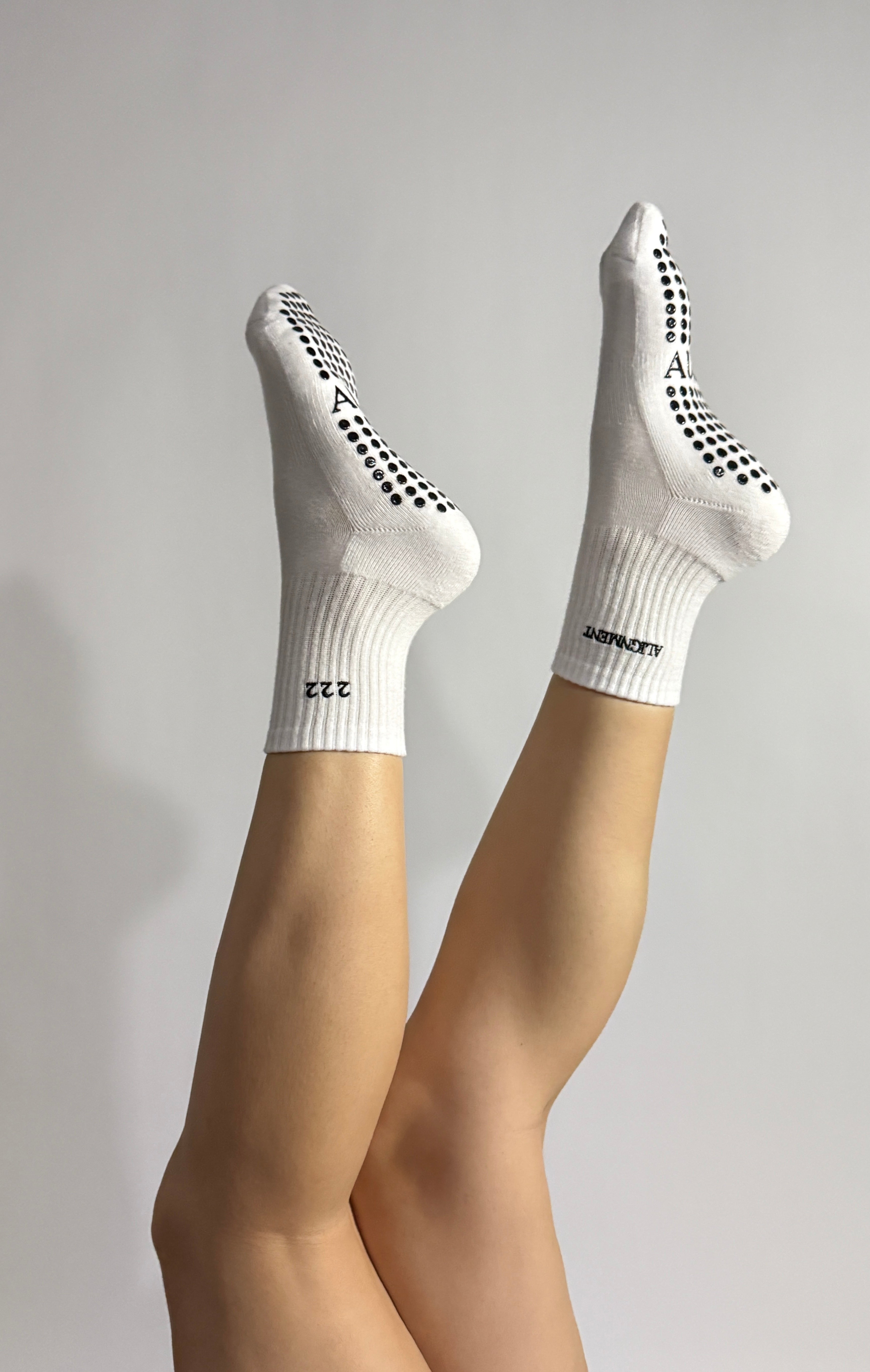 222 White socks with black grip dots worn by a person during a Pilates exercise