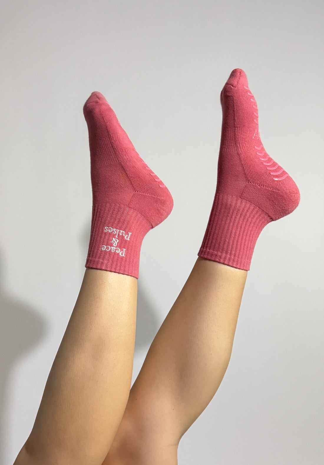 Pink Grip socks worn during a Pilates exercise showing stability, and effortless movement. 