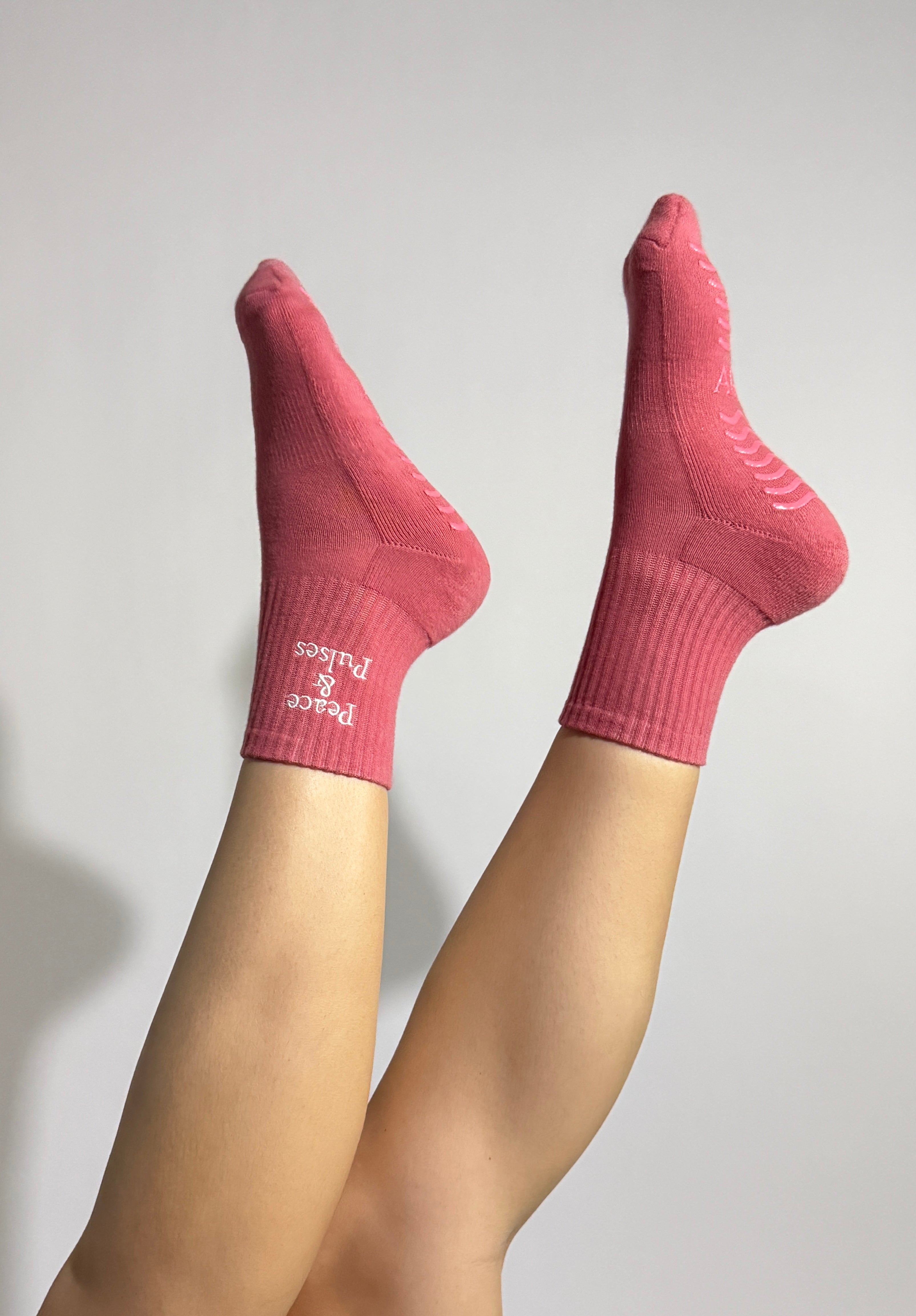 Pink Grip socks worn during a Pilates exercise showing stability, and effortless movement. 